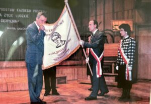 Dyrektor szkoły Lech Przybylski odbiera sztandar IV LO podczas uroczystości nadania IV LO imienia Marii Skłodowskiej-Curie na zdjęciu dyrektor i poczet sztandarowy