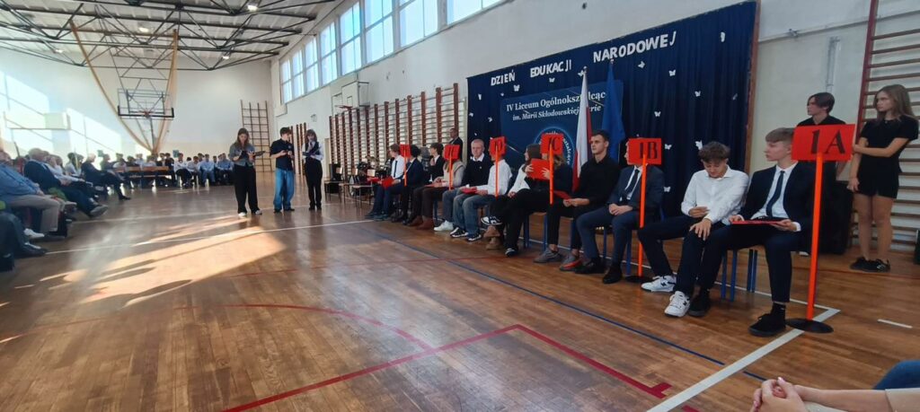 Zdjęcie przedstawia konkurs z okazji ślubowania uczniów Klas I w Dzień Edukacji Narodowej. Zdjęcie zrobione na sali gimnastycznej IV Liceum.