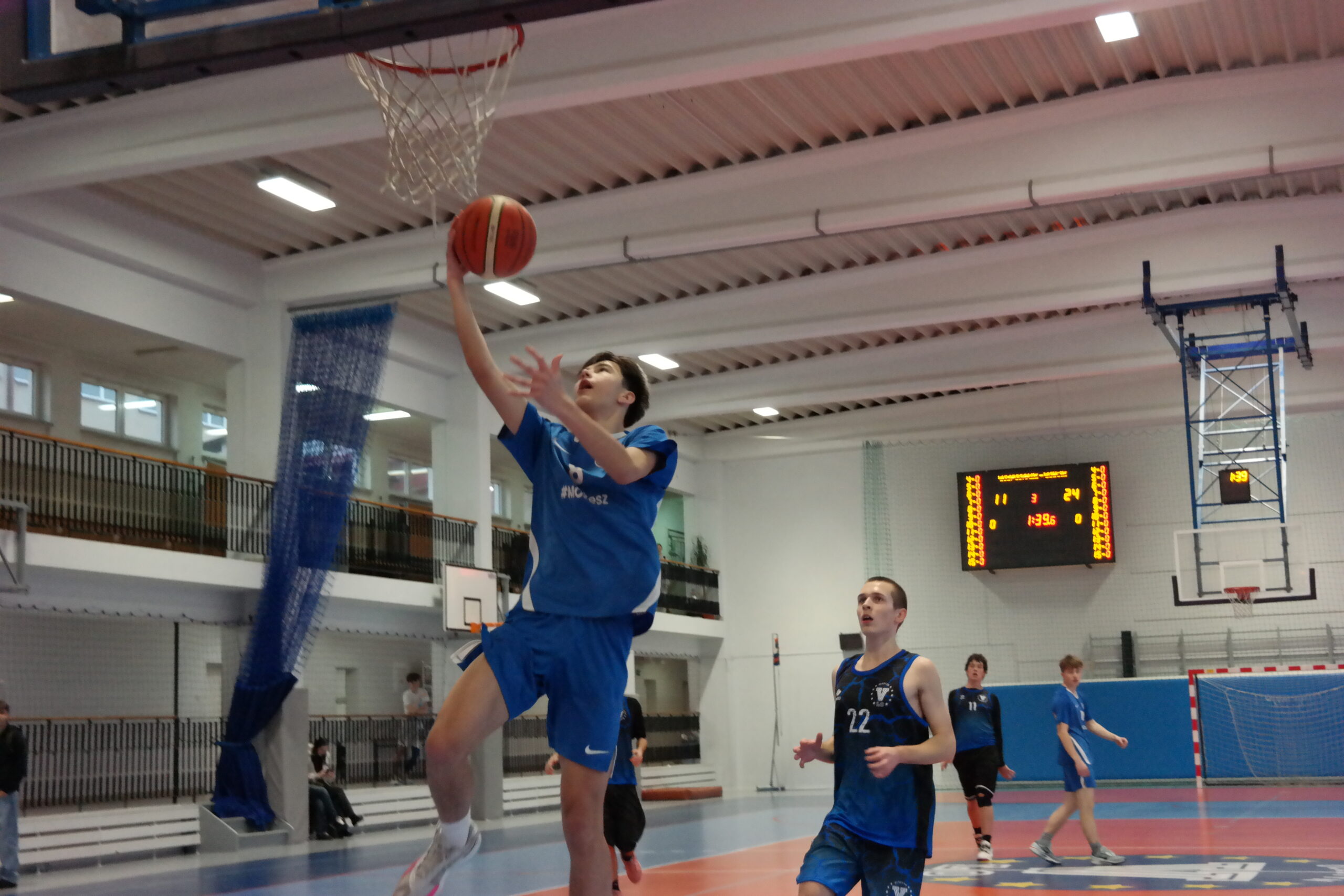 Zawodnik próbuje rzucić piłkę do kosza podczas turnieju koszykówki w V LO w Olsztynie