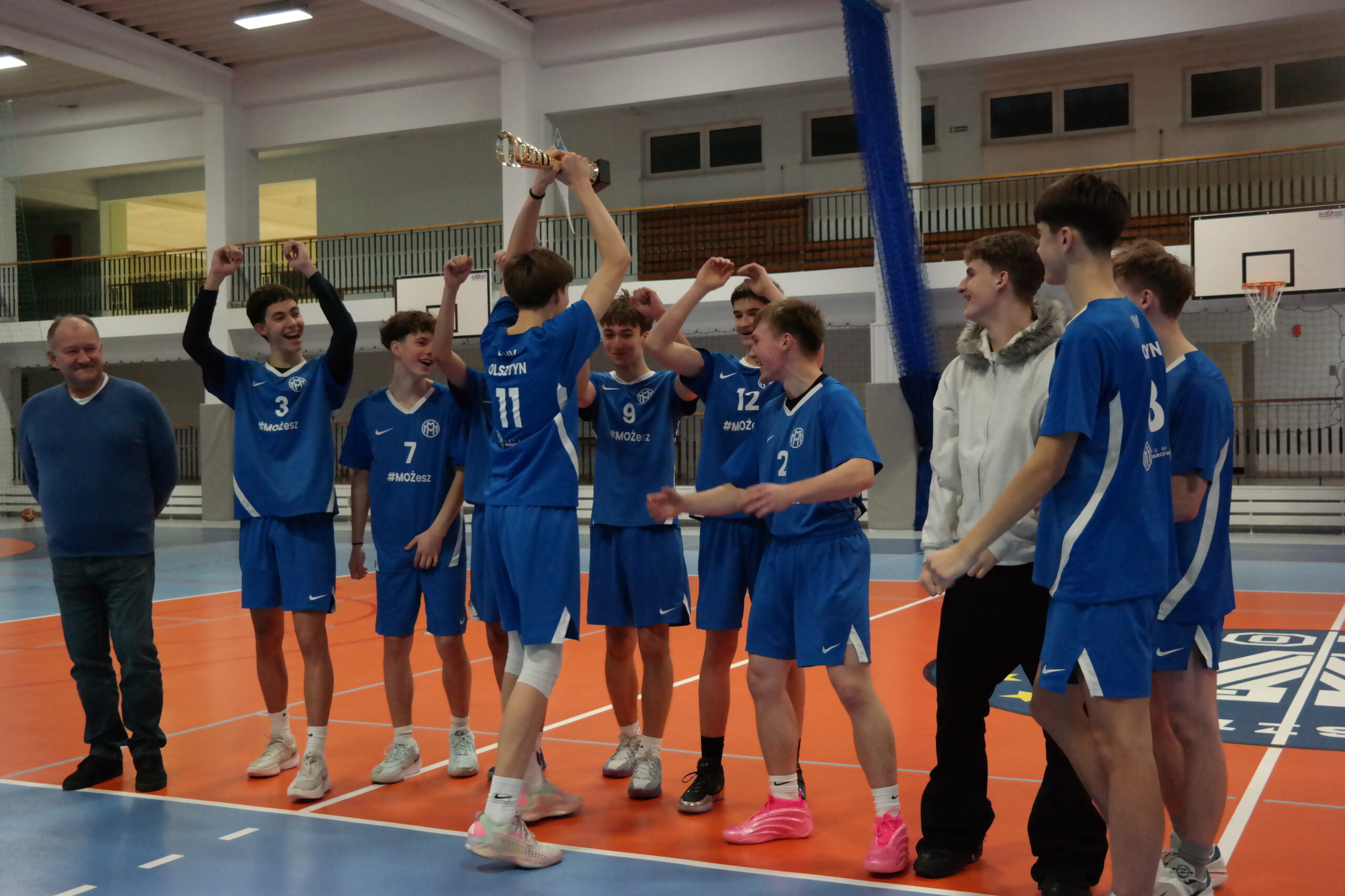 Drużyna koszykarzy z IV LO w Olsztynie z selekcjonerem z pucharem po wygranej olsztyńskich eliminacji do rozgrywek wojewódzkich.